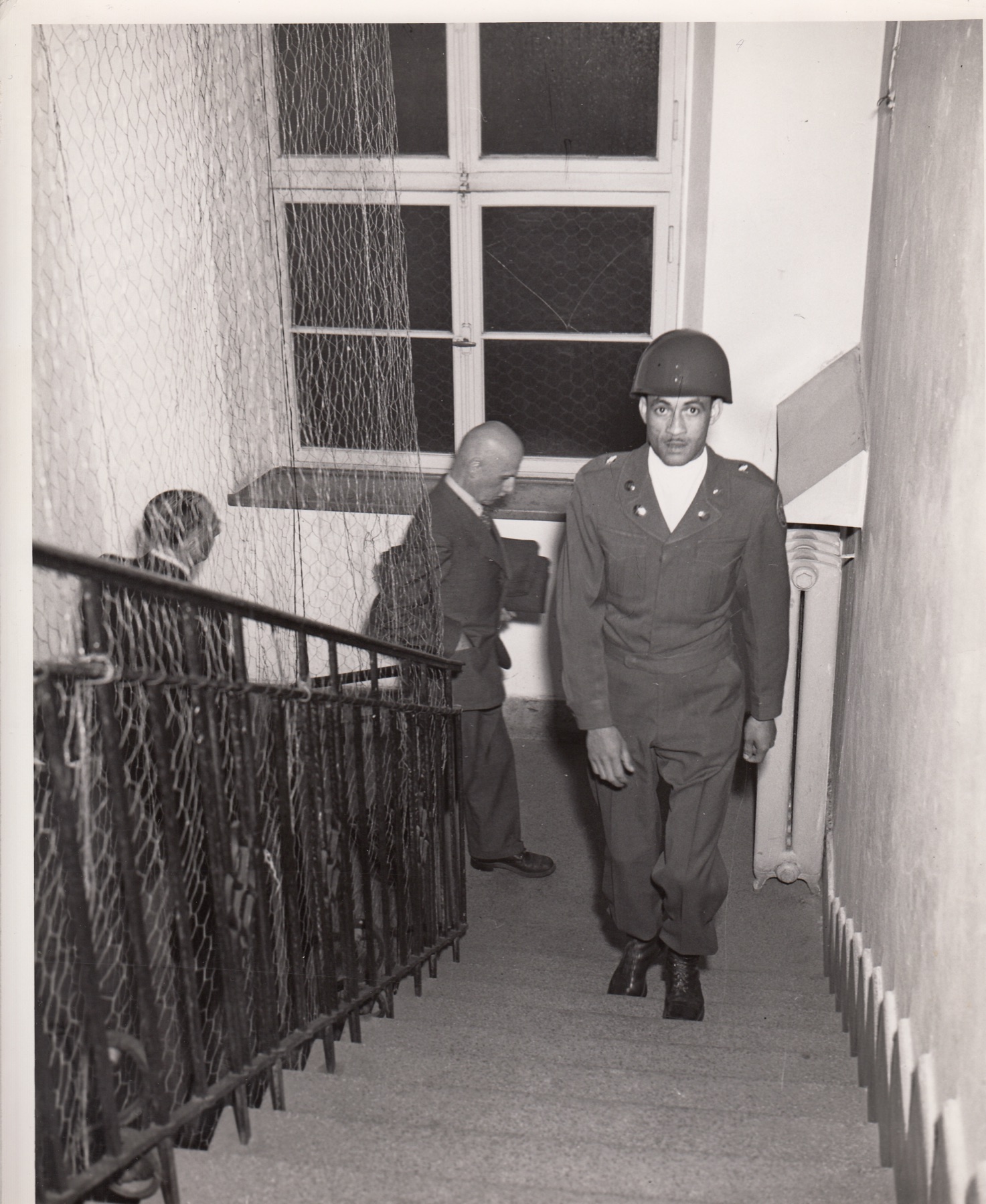Defendants being escorted toward a courtroom